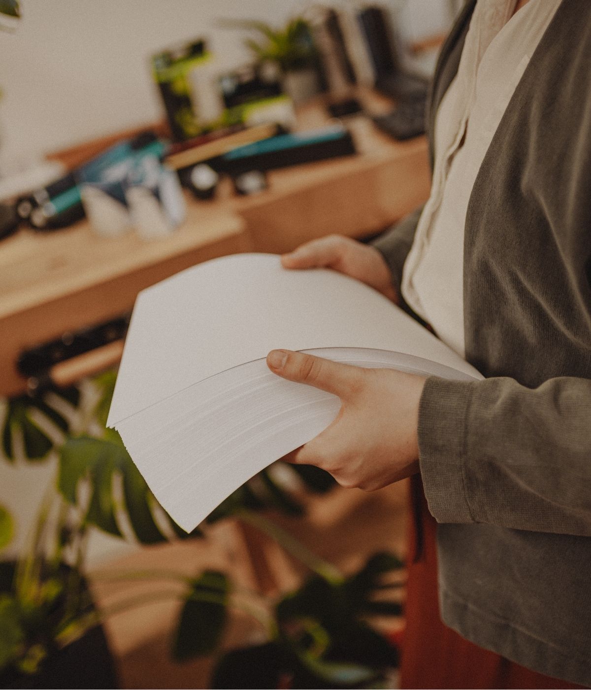 Person hält einen Stapel Papier in den Händen